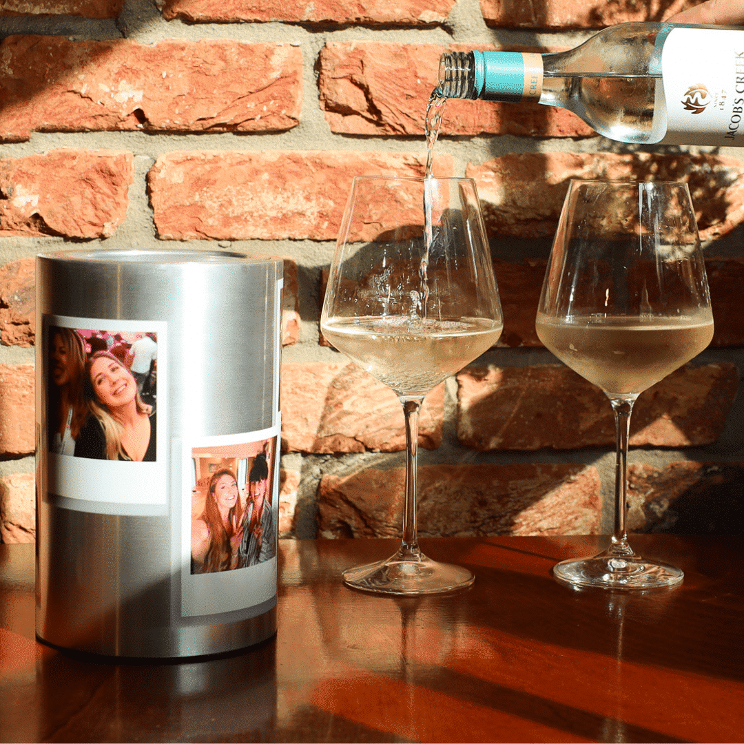 Coolenator wine cooler personalized on a table with two glasses of wine and wine being poored