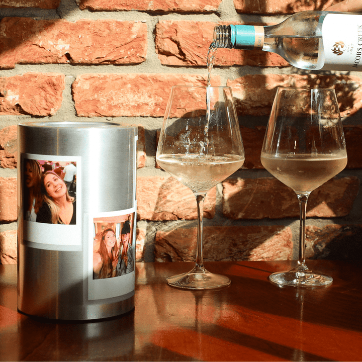 Coolenator wine cooler personalized on a table with two glasses of wine and wine being poored